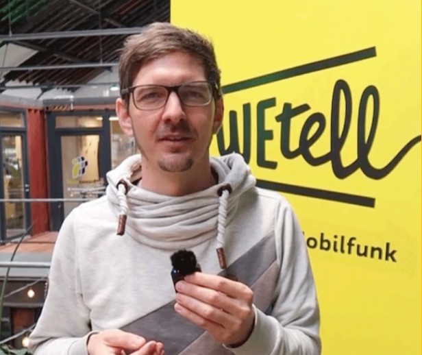 Nico Tucher, Geschäftsführer von WEtell, spricht im Kampagnenvideo zu #IchWähleDemokratie vor einer WEtell-Wand